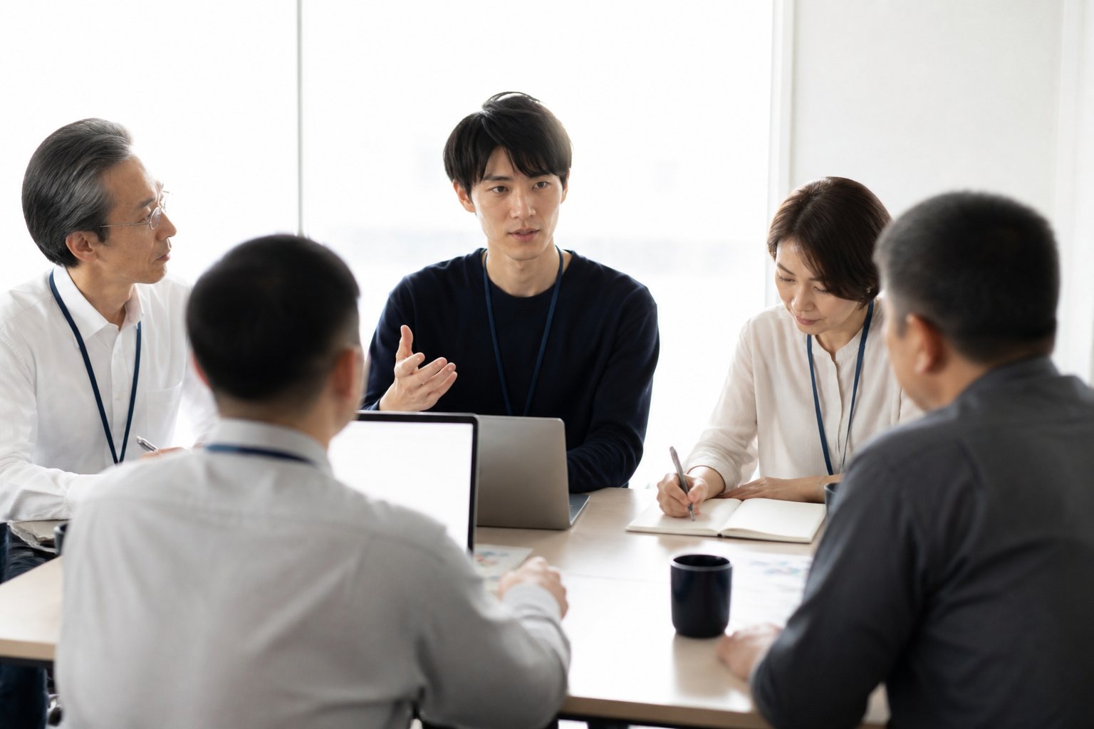 社内勉強会で若手エンジニアが説明し、年上のメンバーが聞いている